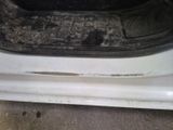 a dirty white car with a dirty seat in the back