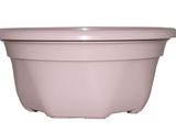 le grand pot rose est posé sur une surface blanche