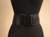 un gros plan sur une femme portant une ceinture en cuir noir