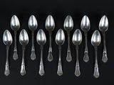 six silver spoons are arranged in a row on a black surface