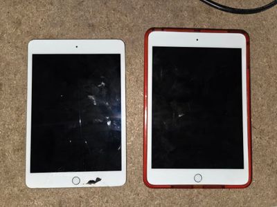 two ipads sitting side by side next to each other on the floor