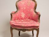une vieille chaise dont l'assise est recouverte d'un tissu rose
