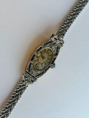 une image d'un gros plan d'une montre-bracelet sur une surface blanche