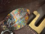 a guitar pick in a case with a keychain on it