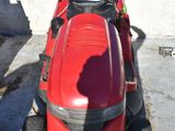 a red lawn mower parked in a parking lot