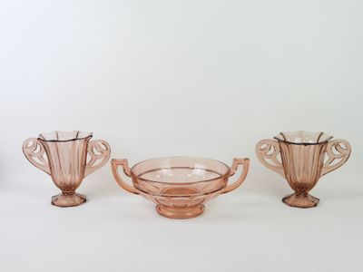 three pink glass vases sitting on top of a white table