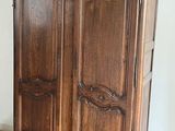a wooden armoire in the corner of a room
