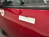 a close up of a red car with a sticker on it
