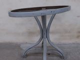 a small table with a wooden top on a concrete floor