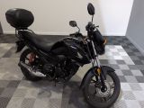 une moto noire garée dans une pièce au sol en damier