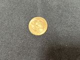 a close up of a gold coin on a black cloth