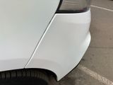 a close up of a white car parked in a parking lot