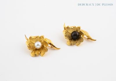 une paire de boucles d'oreilles en forme de fleurs, en or et perles, posées sur un fond blanc