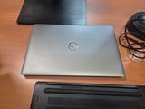 two laptops sitting on a wooden table with a mouse and headphones