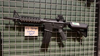 un pistolet accroché à une clôture métallique devant un immeuble