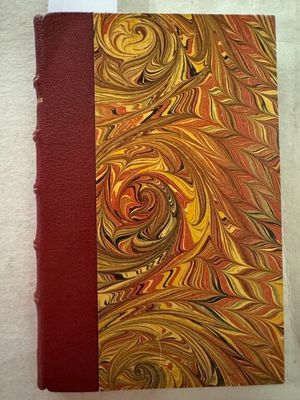 un livre à la couverture rouge posé sur une surface blanche