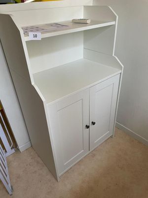a white cabinet with a book shelf in the corner of the room