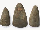 trois morceaux de pierre sont disposés en rangée sur une surface blanche