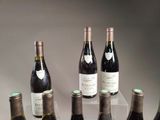 several bottles of wine are lined up on a glass table