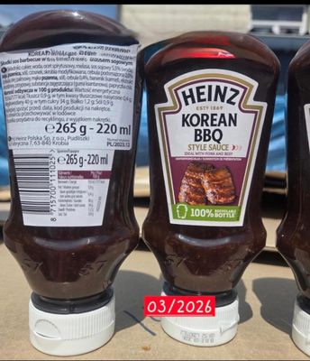 three bottles of ketchup sitting next to each other on a table