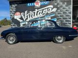 une photo d'une voiture ancienne garée devant un salon de tatouage vintage