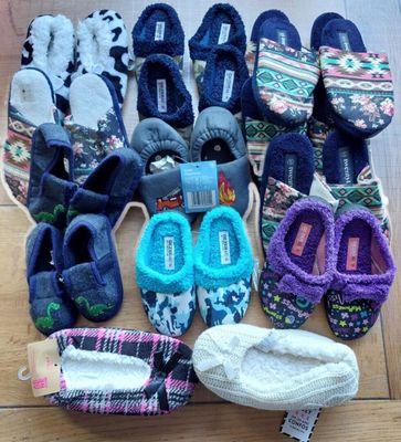 several pairs of slippers are laid out on a wooden floor