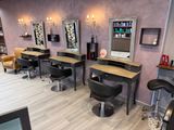 a salon with a lot of chairs and mirrors on the wall
