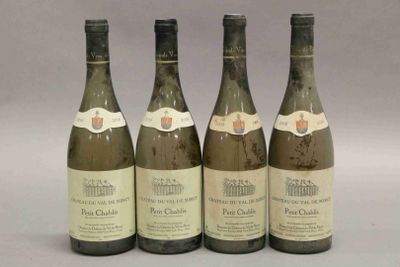 quatre bouteilles de vin sont alignées sur une table
