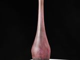 a pink glass vase sitting on a white table