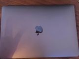 apple laptop sitting on a wooden table with a keyboard and mouse