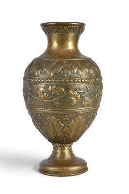 a gold vase that is sitting on a white surface
