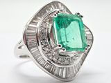an emerald and diamond ring with baguets on a white background