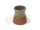 a small cup that is sitting on a white surface