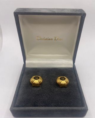 une paire de boucles d'oreilles manchette dorées, présentées dans un coffret cadeau