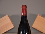a bottle of wine sitting on a table next to a block of wood