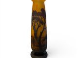 an orange vase with a silhouette of a giraffe and a tree on it