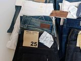 several pairs of men ' s jeans are stacked on top of each other