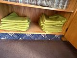 many folded towels sitting on a shelf in a cabinet