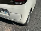 a small white car parked on the side of the road