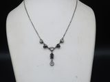 a close up of a necklace on a mannequin with a black background