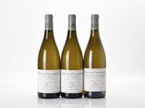 three bottles of white wine sitting next to each other on a table
