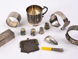 an assortment of silverware and other silverware items on a white surface