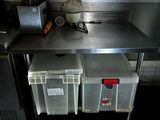 a metal counter with two bins on top of it