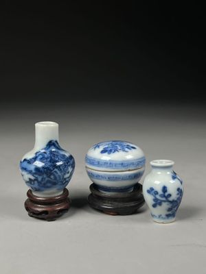 three blue and white vases sitting on top of a wooden stand