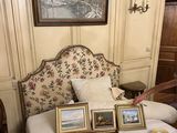 a man that is standing in front of a bed with pictures on it