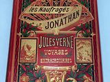 an old book with a red cover and gold lettering on it