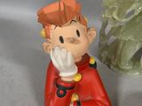 a figurine of a boy sitting next to a christmas tree