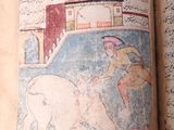 an old book with a picture of a man riding a bull