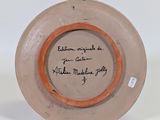 a brown plate with a writing on it on a white surface