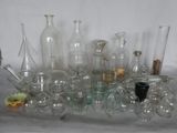 de nombreux vases et bouteilles en verre de toutes sortes posés sur une table